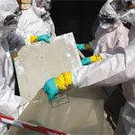 Technician removing block with asbestos fibers.