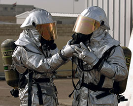 Firefighters wearing respirators on asbestos disposal site.